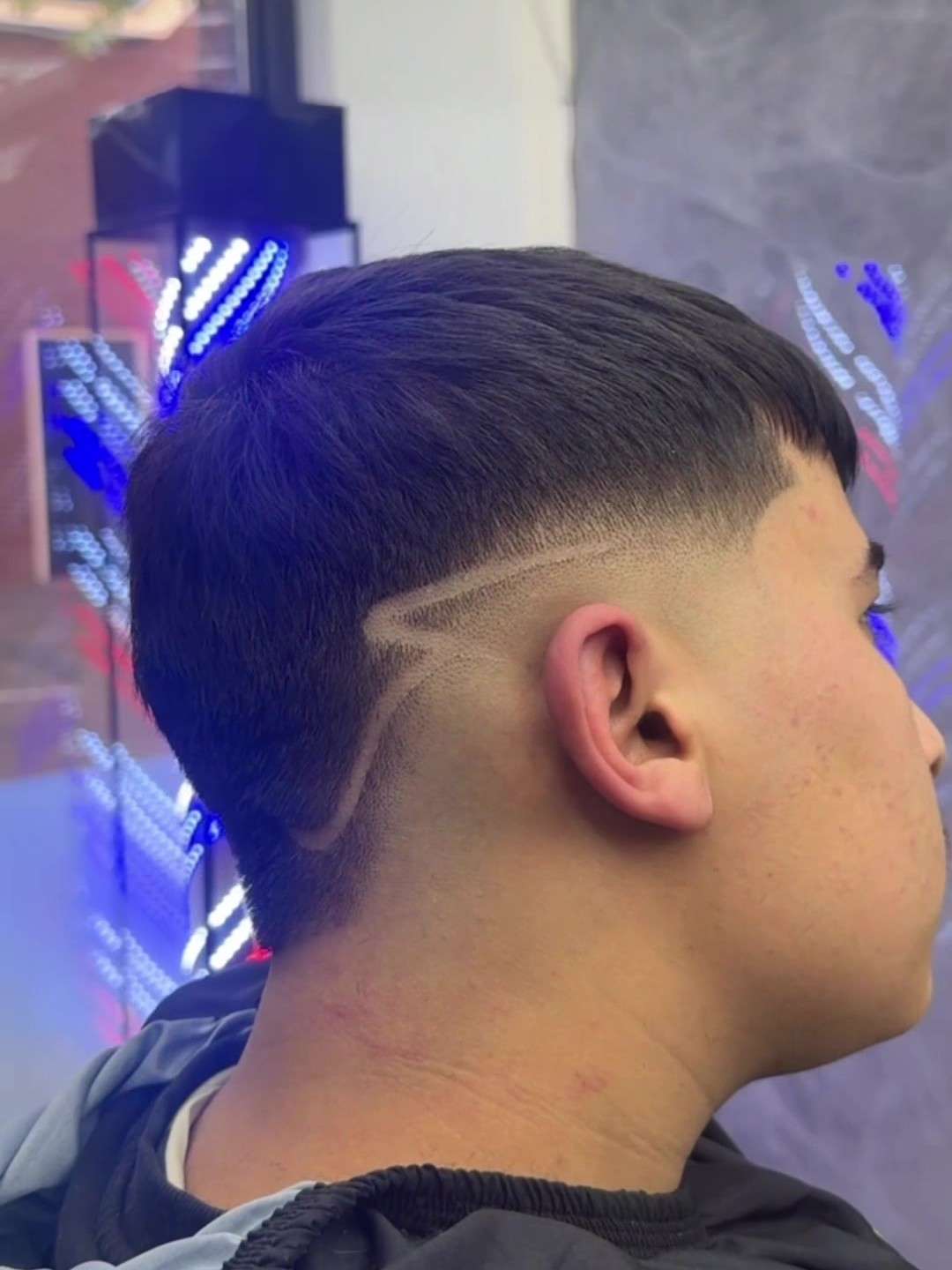 Low fade met een uitgeschoren design-lijn aan de zijkant, gemaakt bij City Style Barbershop Valkenswaard